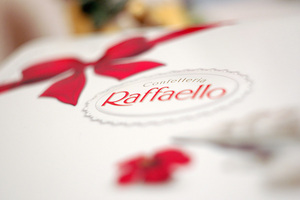коробку Raffaello перевязанную красной атласной ленточкой