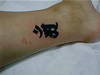 татуировку с иероглифом на щиколотке