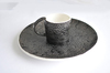 черная чашка с текстурой кружева и черное блюдо
